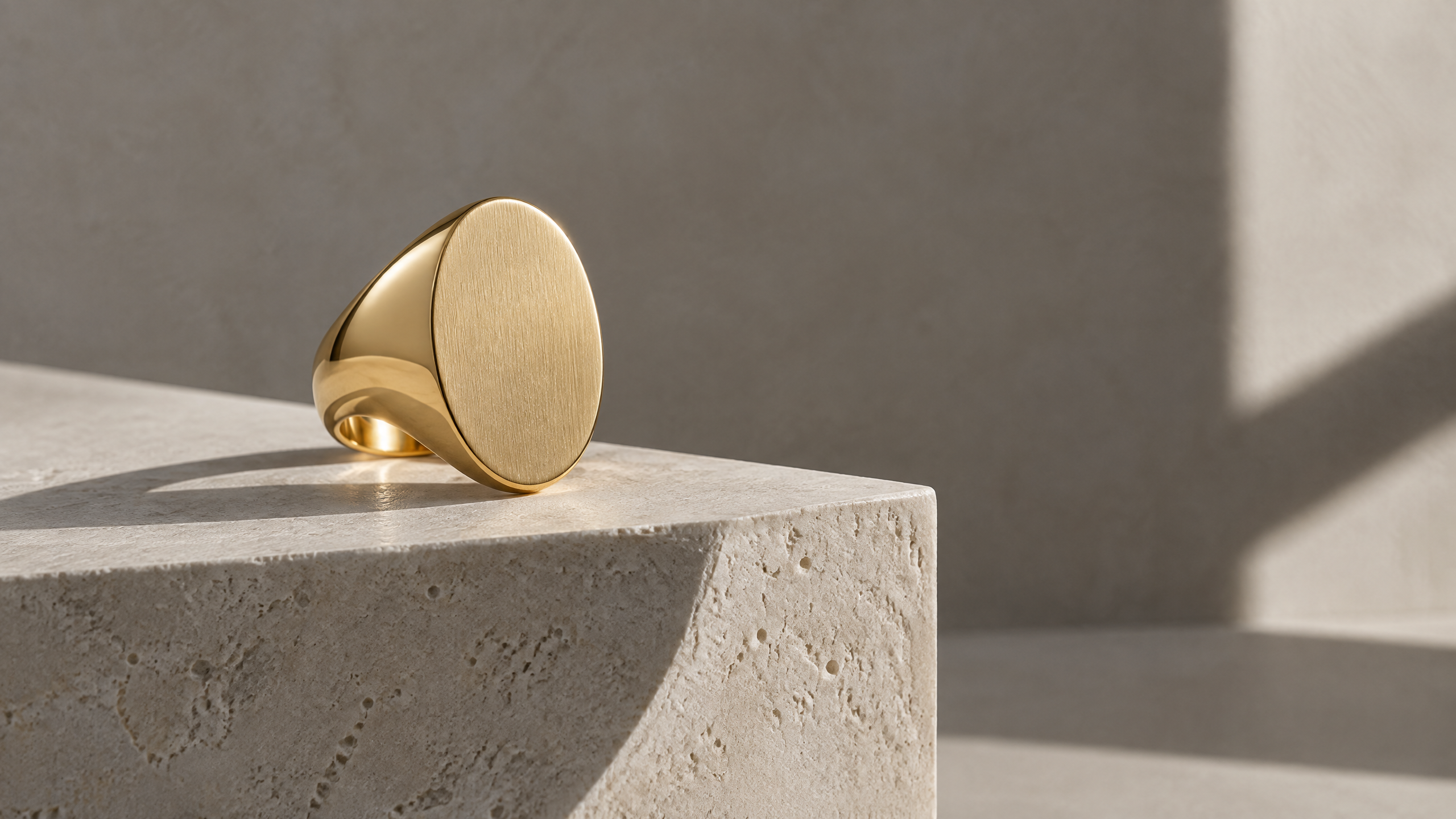 Gold signet ring on warm stone